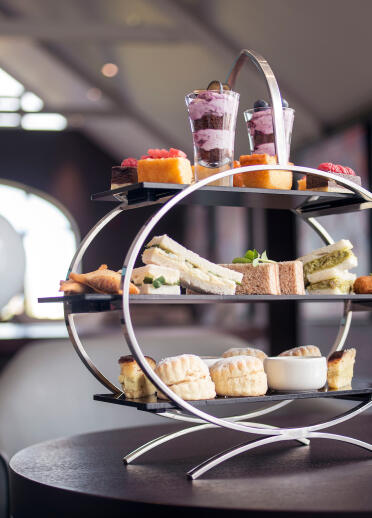 A round tiered cake stand filled with afternoon tea delights.