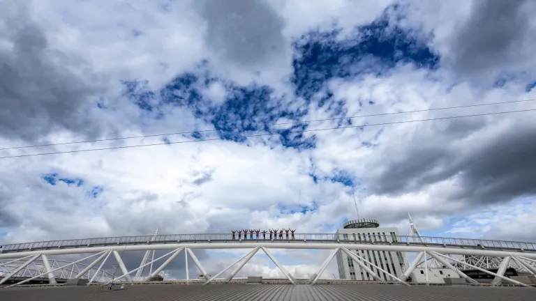Group of people on a walkway above a sports stadium.