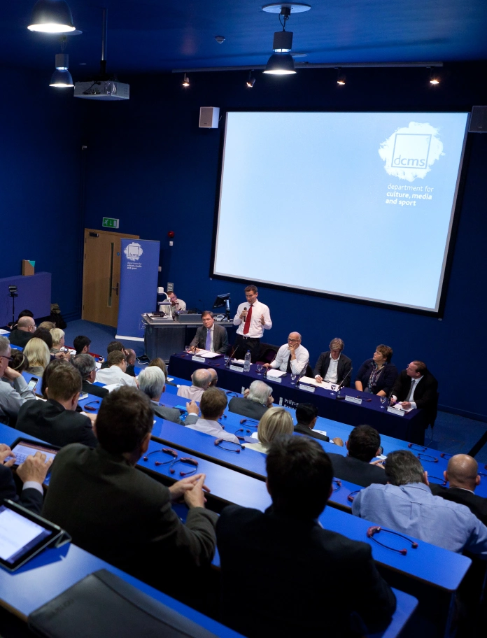 A lecture being delivered at a theatre style conference room.