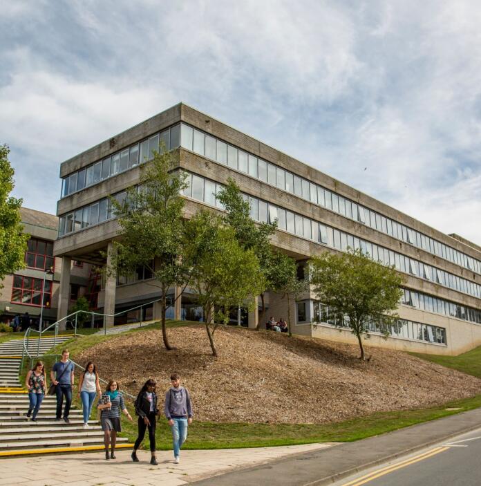 External view of a university building with students walking down the steps.