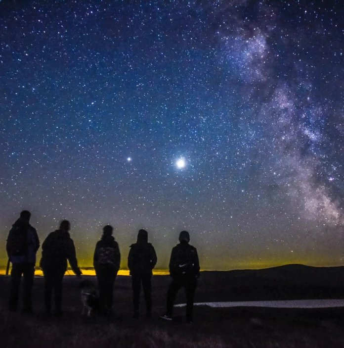 People standing on a mountain watching the stars on the dark Sky reserve 
