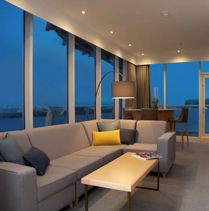 A stylish lounge area with dual aspect floor to ceiling windows overlooking the bay.