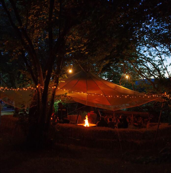 Festival at the tipi in the evening, adorned with fairy lights.