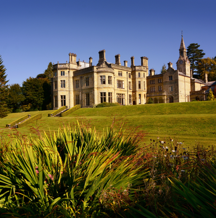 A grand hall hotel taken from the manicured gardens.