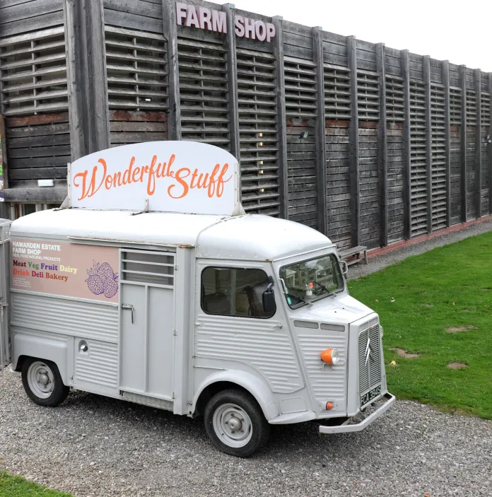 Grey van outside a farm shop building. 