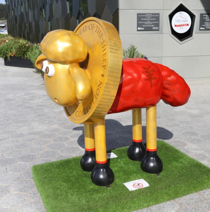 A model of Shaun the sheep wearing a coin.