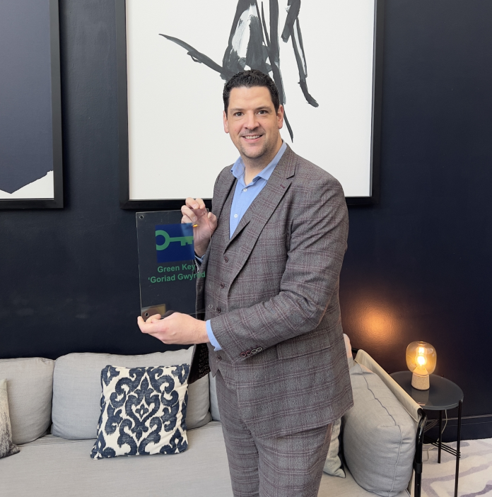 Neil Parry holding green key accreditation award.