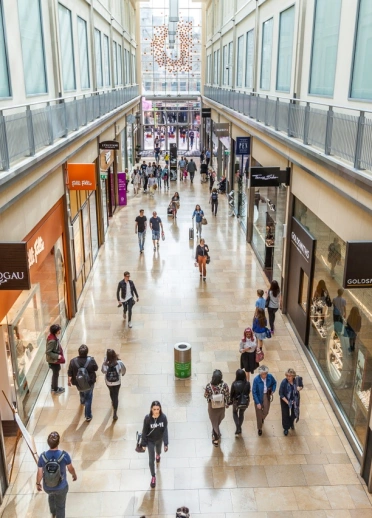 Shoppers walking through a shopping centre.