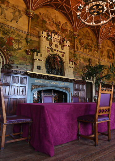 Medieval dining table in an ornately decorated banqueting hall.