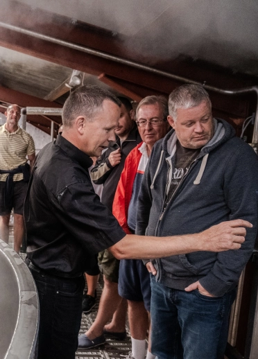 A group of people taking a tour around a brewery.