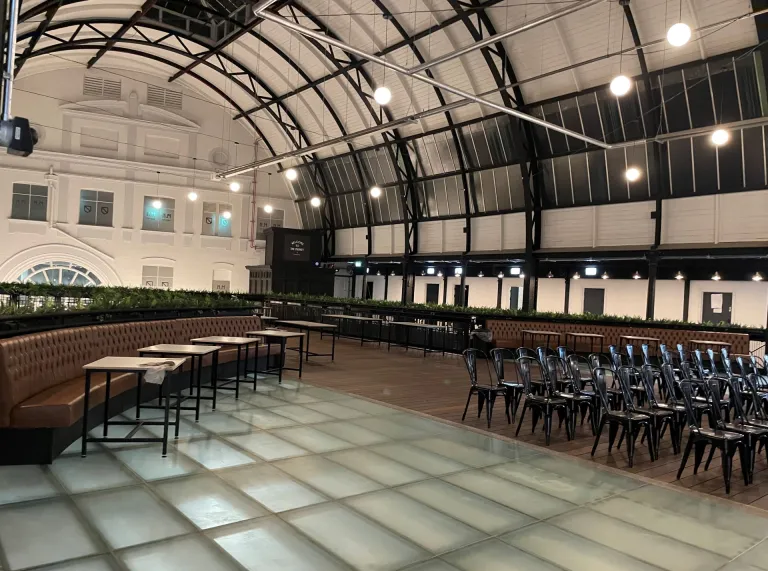 Tables and chairs laid out for meeting space in a Victorian market.