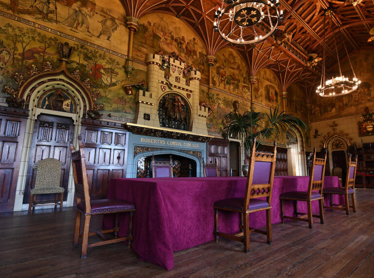 Medieval dining table in an ornately decorated banqueting hall.