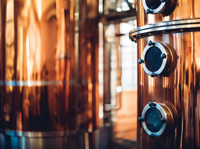A close up of a copper vat for distilling gin.