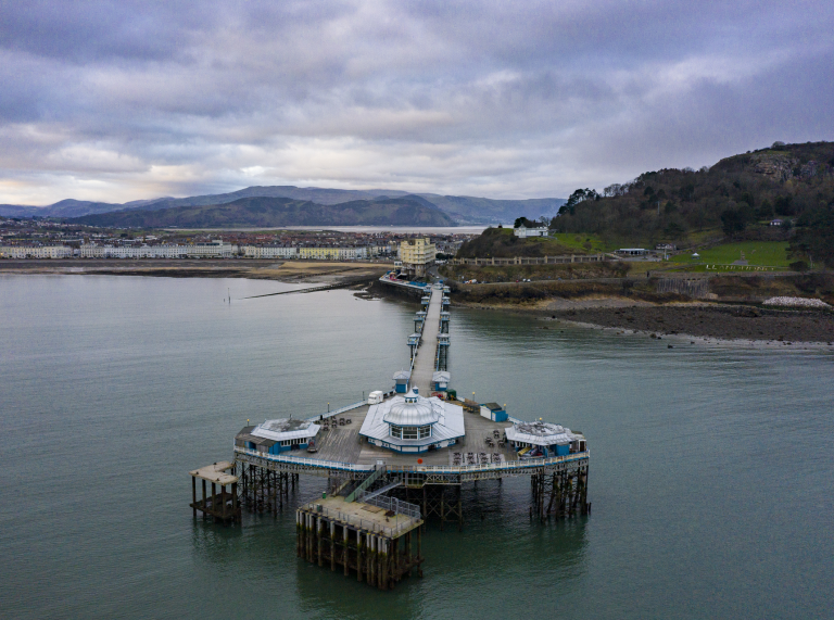 Aerial view of a pier and coastline from out at sea.