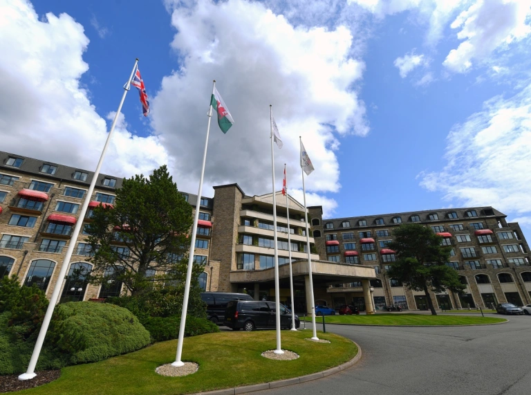 Flags on masts leading to an entrance of a resort hotel.