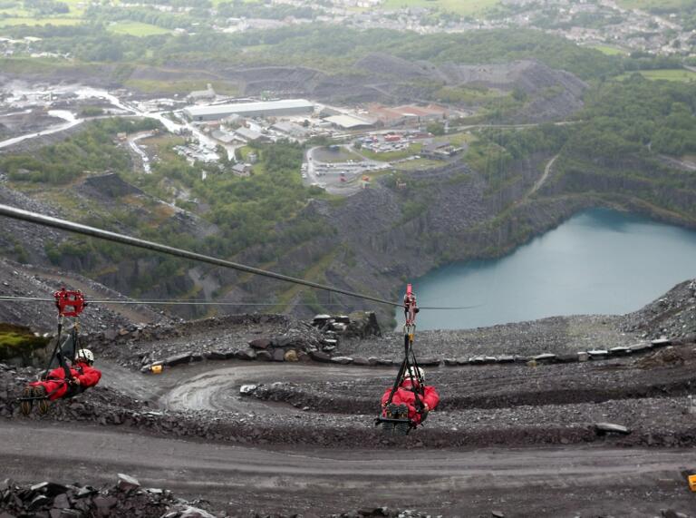 Two people on a Zip Line over Penrhyn Quarry.
