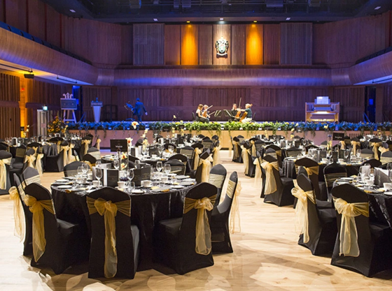 Great Hall set up for a gala dinner with musicians rehearsing on stage.