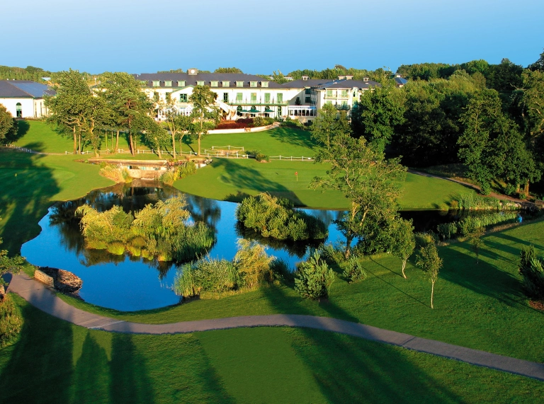 Aerial shot of a hotel, lake and golf course.
