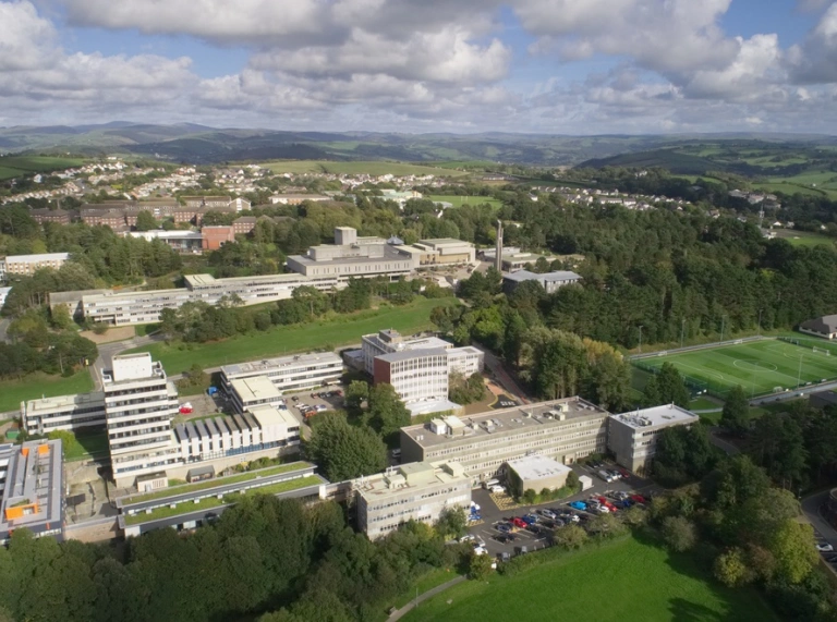 Aerial view of a university building surrounded by playing fields.