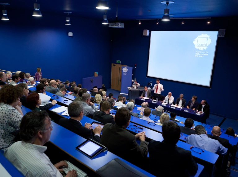 A lecture being delivered at a theatre style conference room.