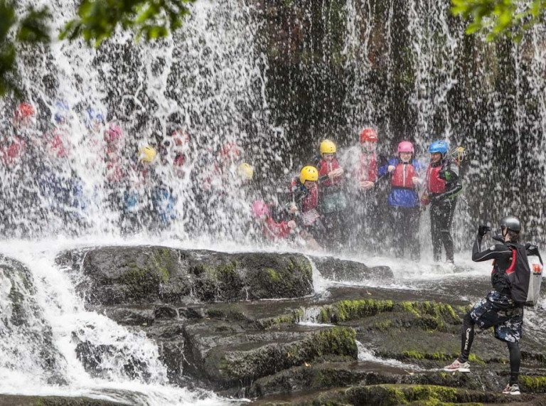 Group of people behind a waterfall