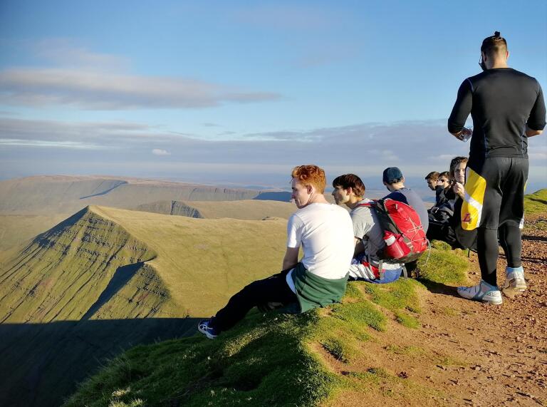 Group of people sitting on the top of Pen y Fan