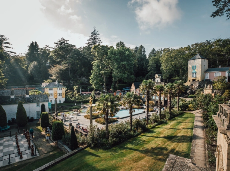Looking over green landscapes gardens and white buildings in Portmeirion Village