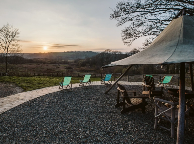 Outdoor tipi with chairs overlooking the mountains of Cardigan and sun setting