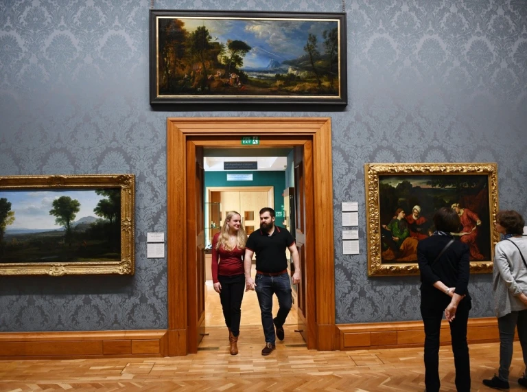 people walking through teh national museum Cardiff looking at art on the walls