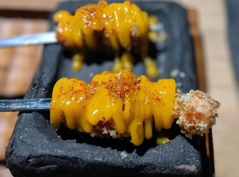 food served on a skewer on a black slate plate