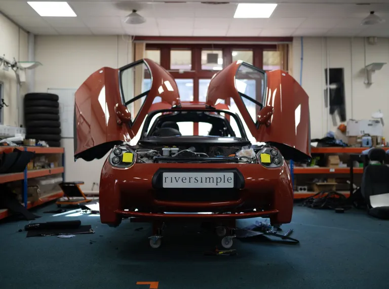 Red Riversimple Hydrogen car with doors open in workshop