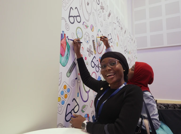 Two delegates of the conference in the well-being space drawing to relax 