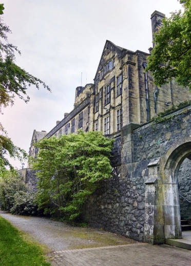 An external view of a university alongside a path lined with greenery.