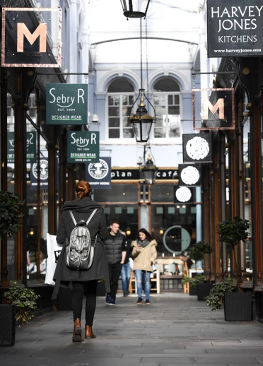 Shoppers walking through a victorian arcade in Cardiff.