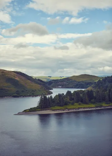 Lakes and green mountains and trees with blue sky.