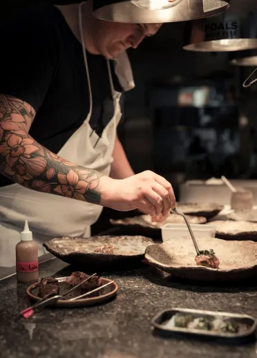 A head chef preparing a plate of food.