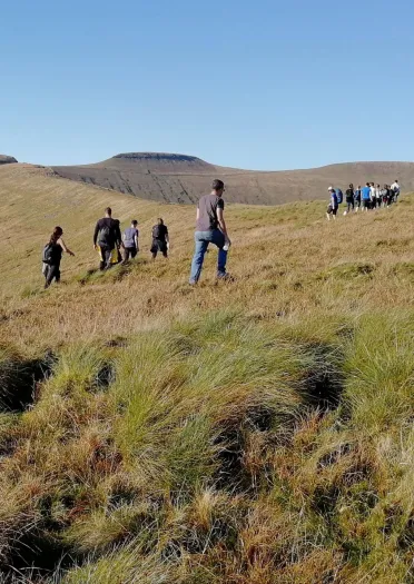 A group of people walking up a mountain