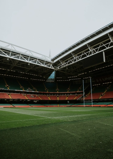 On the pitch at a major sports arena with rows of seating and rugby posts.