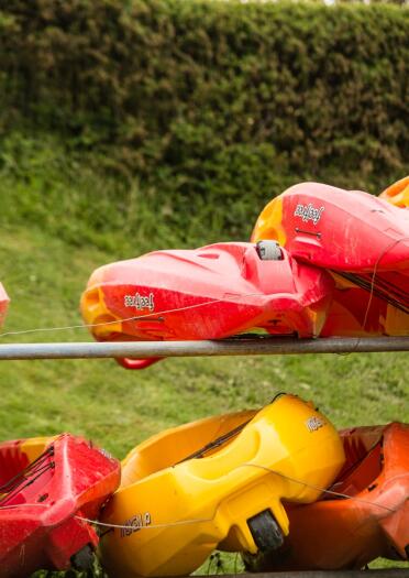 Red and yellow canoes stacked up on shelves.