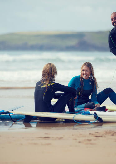 Kirsty Jones on the beach with friends and surfboards