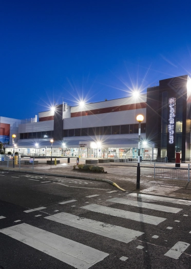 External shot of Cardiff Airport brightly lit at night.