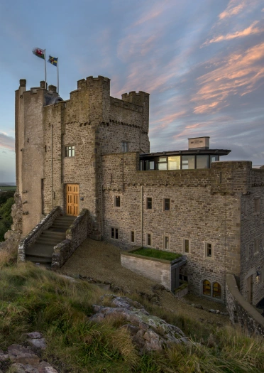 A castle hotel on a hill at sundown.