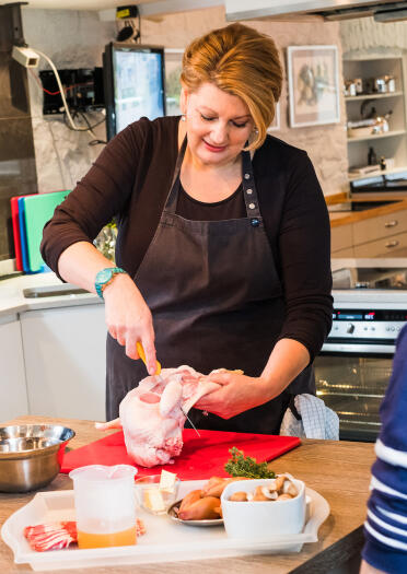 Angela Gray demonstrating how to fillet a chicken at her cookery school.
