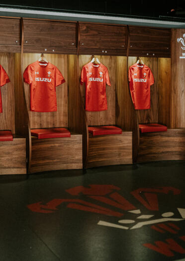 Welsh rugby shirts hung up in a dressing room.