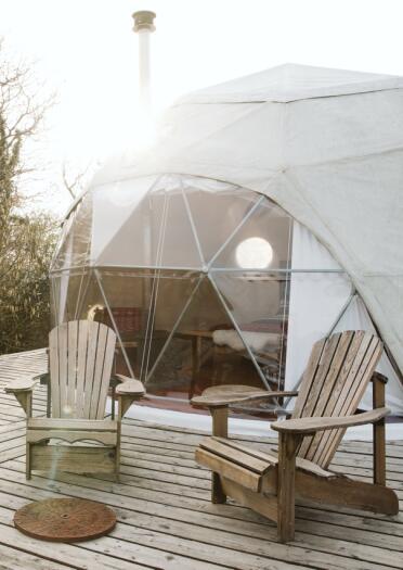 Accommodation dome with chairs outside on wooden decking. 