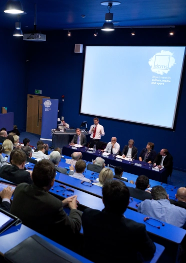 A lecture being delivered at a theatre style conference room.