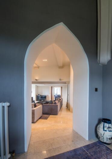 A lounge area seen through an archway in a castle hotel.