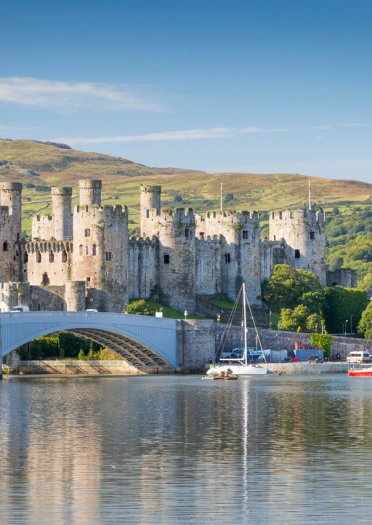Conwy Castle against the mountains and quay