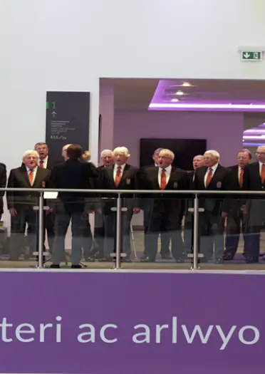 A group of men standing in a row singing, choir