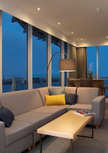 A stylish lounge area with dual aspect floor to ceiling windows overlooking the bay.